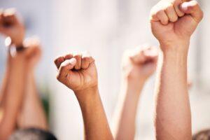 Hands, fist and people for protest with teamwork, human rights and diversity in collaboration with power.