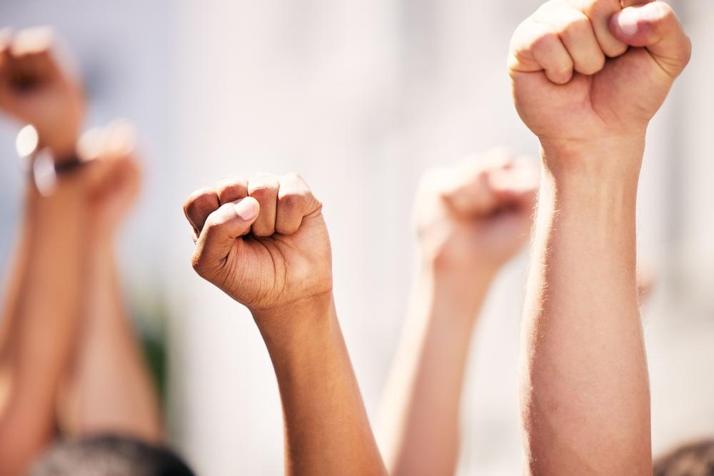 Hands, fist and people for protest with teamwork, human rights and diversity in collaboration with power.