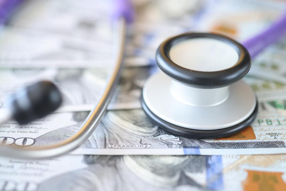 Medical instrument stethoscope lying on set of american dollars closeup.